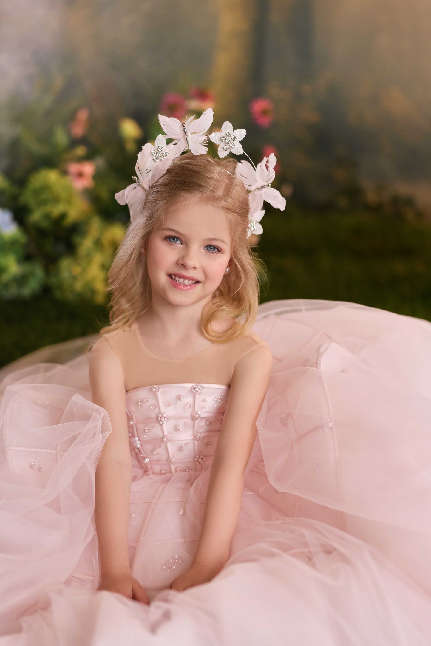 Detailed close-up of a children's formal gown bodice showing intricate lattice patterns, mini fabric blossoms, and shimmering crystal beads.