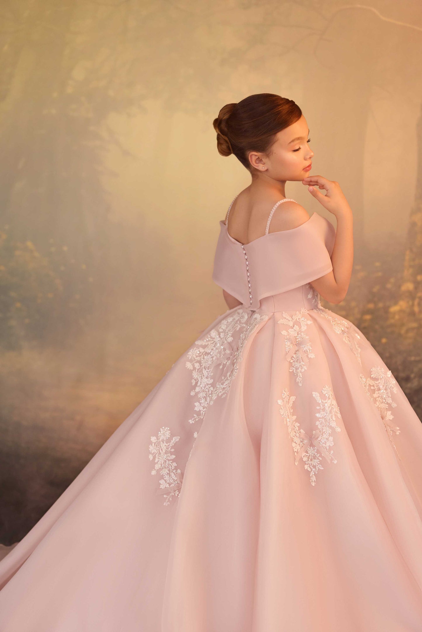 Back view of a premium pink flower girl dress featuring a dramatic sweeping floor-length ball gown train.