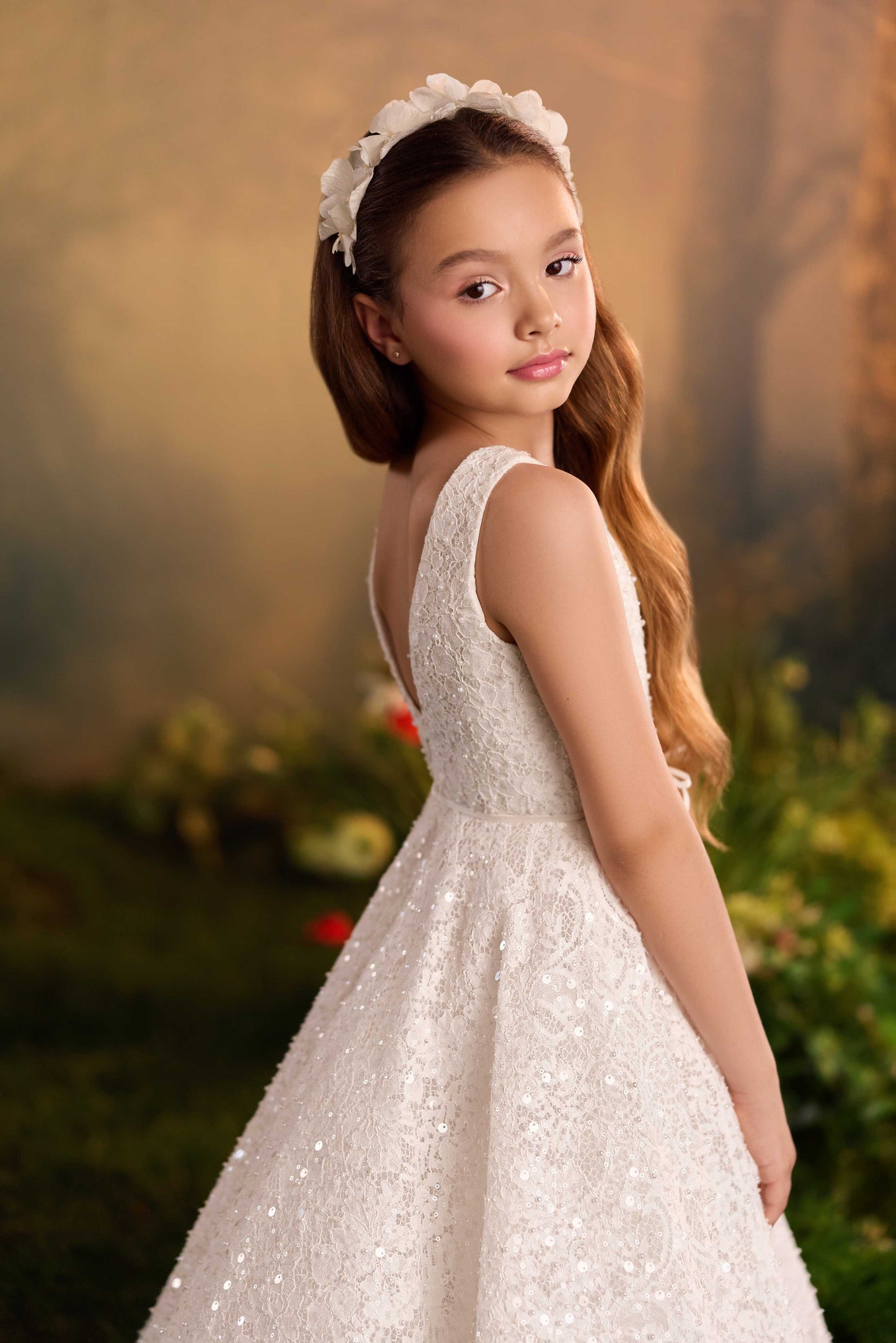 Close-up back view of a white flower girl gown showing the hidden zipper closure and satin waistband bow.