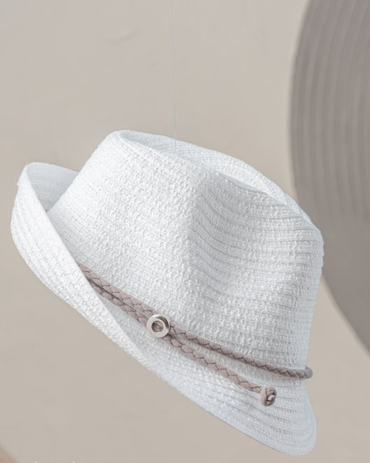 White straw hat with a decorative band on a beige background